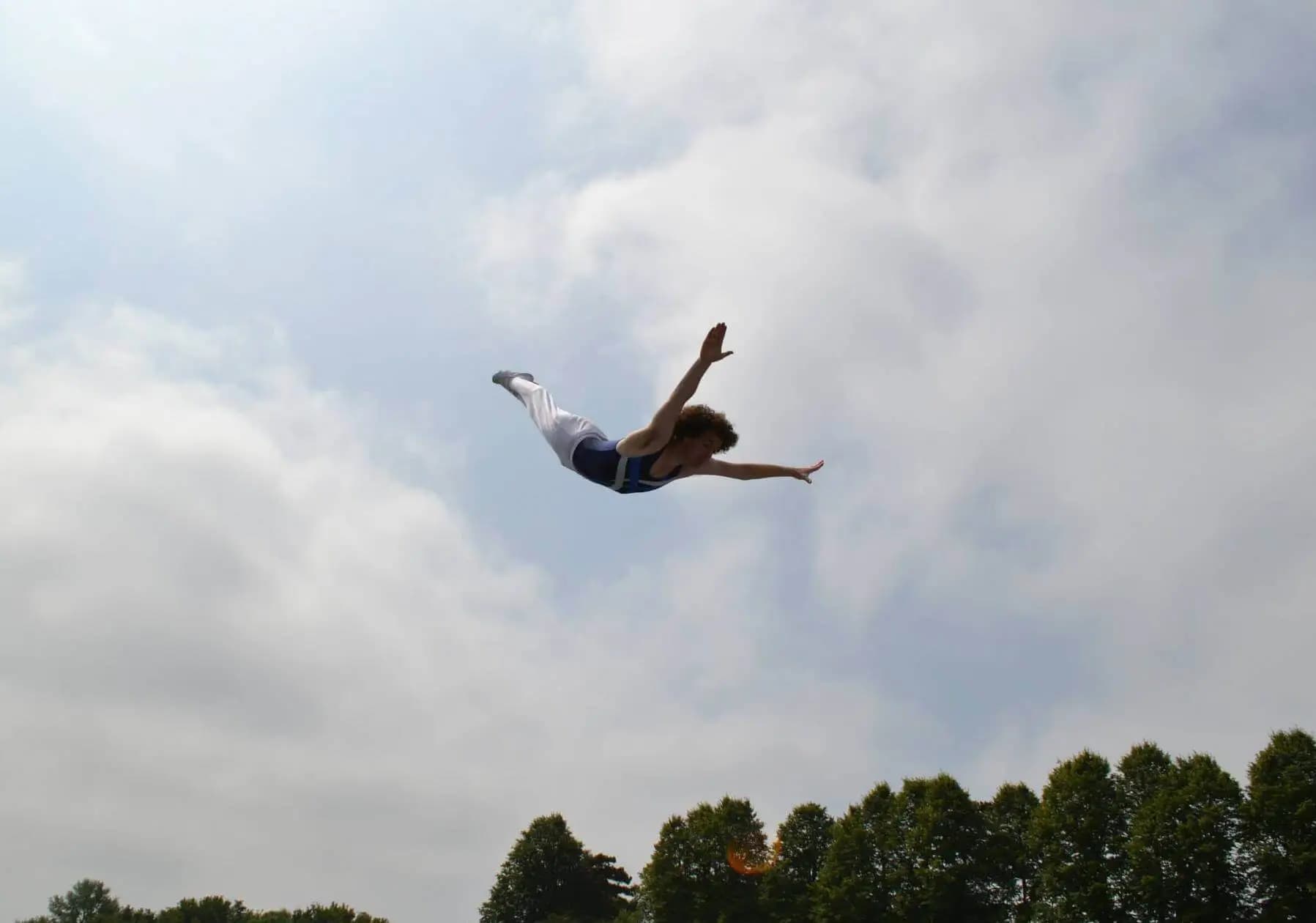 Ali trampolining outside somersaulting in the air